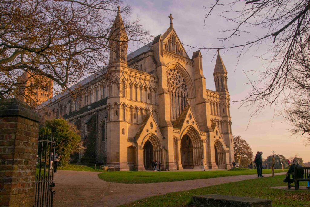 The historic St Albans Cathedral lit by the warm glow of a sunset in England.